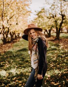 Student poet Lydia Hofmann outside in Fall with hat